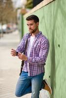 Attractive young man standing in urban background. Lifestyle concept.