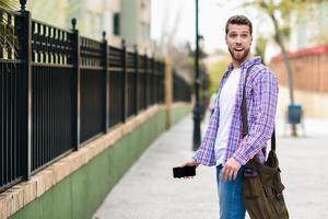 Young bearded man surprised in urban background. Lifestyle concept.