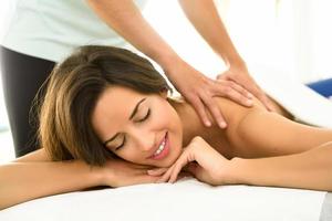 Young woman receiving a back massage in a spa center. photo