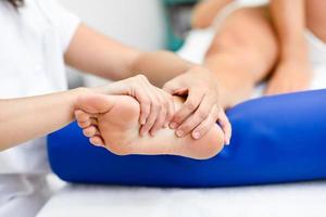 Medical massage at the foot in a physiotherapy center. photo