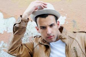 Attractiv young man with a hat in urban background photo