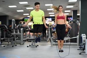 Man and woman workout with jumping rope in crossfit gym photo