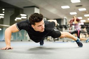 Hombre atractivo haciendo flexiones en el gimnasio foto