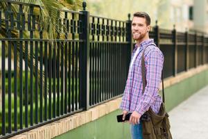 Young bearded man standing in urban background. Lifestyle concept. photo