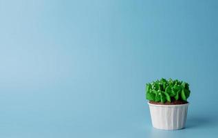 Christmas tree shaped cupcakes on blue background photo