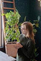mujer joven cuidando las plantas en casa