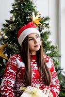 mujer joven, en, rojo, suéter, tenencia, regalo de navidad
