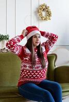 Young woman sitting on couch alone in a decorated for Christmas living room photo