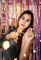 woman in glitter dress holding christmas lights photo