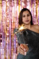 woman in glitter dress holding sparkler, close up hands, romantic look
