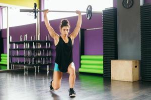 Athletic woman in gym lifting weights at the gym photo