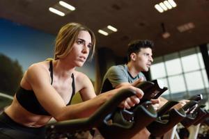 pareja en una clase de spinning vistiendo ropa deportiva. foto