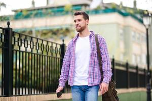 Young bearded man walking in urban background. Lifestyle concept.