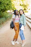 Dos mujeres multiétnicas posando junto con ropa casual colorida foto