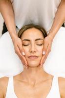 Middle-aged woman having a head massage in a beauty salon. photo