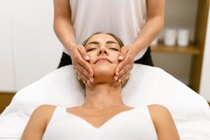 mujer de mediana edad con un masaje de cabeza en un salón de belleza. foto
