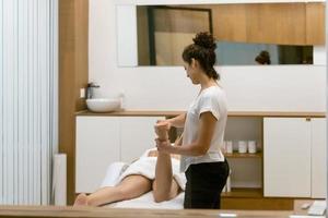 Middle-aged woman having a leg massage in a beauty salon.