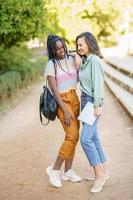 Two multiethnic girls posing together with colorful casual clothing photo