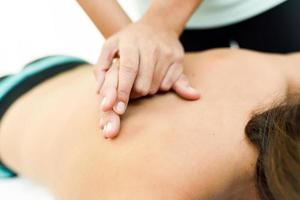 mujer joven recibiendo un masaje de espalda en un centro de spa. foto