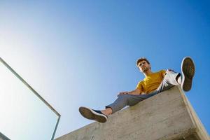 Man sitting on a ledge looking around photo