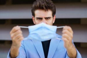 Businessman putting on a surgical mask to protect against the coronavirus. photo