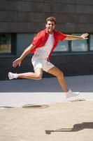Man wearing casual clothes jumping in urban background. photo