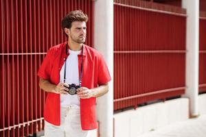 Hombre milenario tomando fotografías con una cámara réflex foto