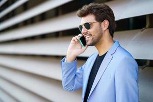 hombre hablando con su teléfono inteligente con una expresión feliz foto