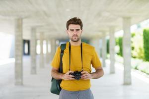 Hombre milenario tomando fotografías con una cámara réflex foto