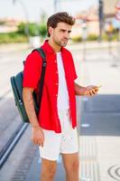 joven esperando un tren en una estación exterior foto