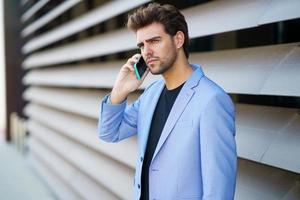 Businessman talking to his smartphone wearing blue suit. photo