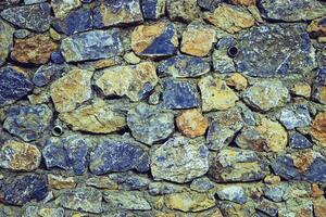 Pared de piedra azul y amarilla abstracta ornamento de textura realista construcción de roca en la naturaleza. foto