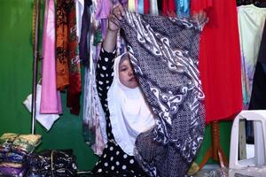 Batik traders when arranging their selling items in the shop at Pekalongan Central Java Indonesia photo