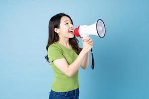 Asian girl portrait holding speaker, isolated on blue background photo