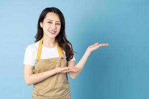 Asian female waitress portrait, isolated on blue background photo