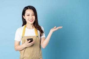 Asian female waitress portrait, isolated on blue background photo