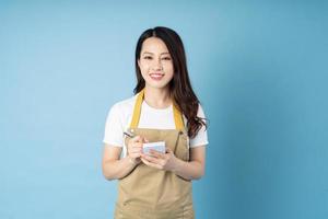 Asian female waitress portrait, isolated on blue background photo