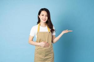 Asian female waitress portrait, isolated on blue background photo