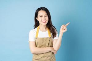 Asian female waitress portrait, isolated on blue background photo