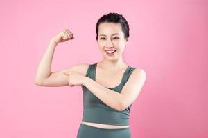 Retrato de niña asiática fitness, aislado sobre fondo rosa foto