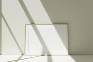 Maqueta de marcos de fotos de madera horizontales en el piso apoyado contra la pared de la habitación con sombra