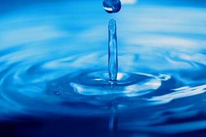 Salpicaduras de gota de agua transparente azul con burbuja realista con azul. foto