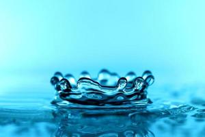 light blue transparent water wave surface with splash bubble on blue. photo