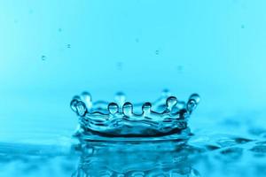 Superficie de onda de agua transparente azul claro con burbuja de salpicadura en azul. foto