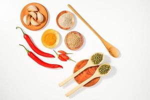 variety of spices and herbs prepared on the white table. food condiment recipes from the top view. suitable for social media or website background presentation.