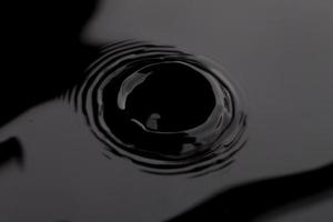 Superficie de onda de agua transparente negra oscura con burbuja de salpicadura sobre agua negra. foto
