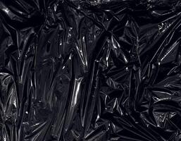 a transparent plastic wrap on black background. realistic plastic wrap texture for overlay and effect. wrinkled plastic pattern for creative and decorative design. photo