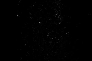 las partículas blancas sobre fondo negro que representan una nevada. metraje de superposición de nieve para dar un efecto de congelación o invierno a la presentación del video. foto