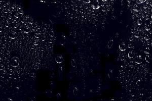 gotas de agua sobre fondo negro. Gotas de agua de rocío abstracto en el vidrio de una ventana para un efecto de superposición de fotos o para dar un efecto fresco en la maqueta de bebidas. tiro macro de la gota de agua detallada.