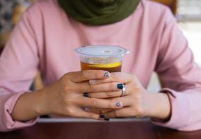 a lady enjoys her drink at a traditional vibes restaurant. summer vibes in Indonesia. photo